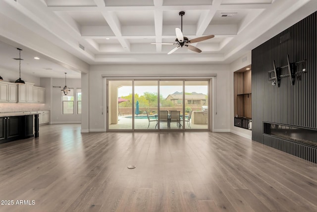 living room with wood finished floors, visible vents, baseboards, and ceiling fan