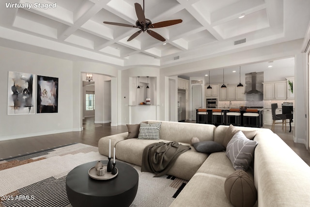 living area featuring beamed ceiling, ceiling fan, visible vents, and coffered ceiling