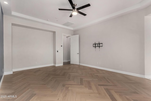 empty room featuring visible vents, a ceiling fan, and baseboards