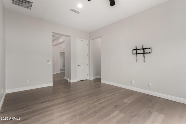 unfurnished room with baseboards, wood finished floors, and visible vents