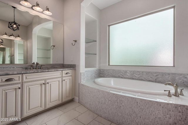 bathroom with a bath, marble finish floor, and vanity