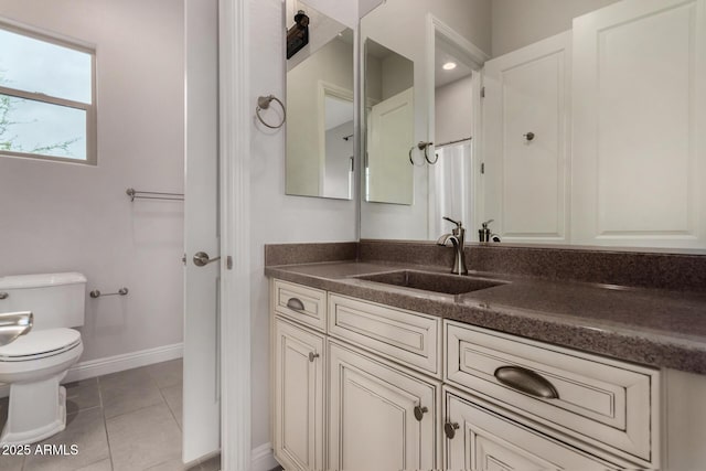 bathroom with tile patterned flooring, toilet, vanity, and baseboards