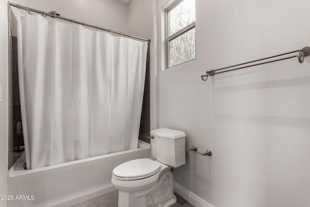 bathroom featuring shower / bath combo, baseboards, and toilet