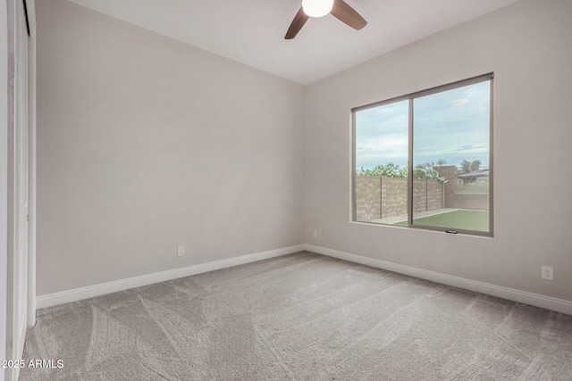 empty room featuring a ceiling fan, carpet floors, a healthy amount of sunlight, and baseboards