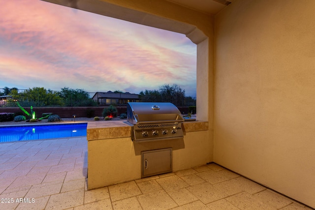 pool at dusk with a patio area, an outdoor pool, and area for grilling