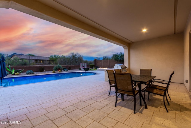 pool at dusk with a fenced in pool, a fenced backyard, grilling area, outdoor dining area, and a patio