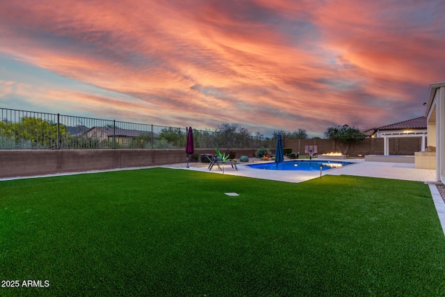 pool at dusk with a lawn, a fenced backyard, a fenced in pool, and a patio
