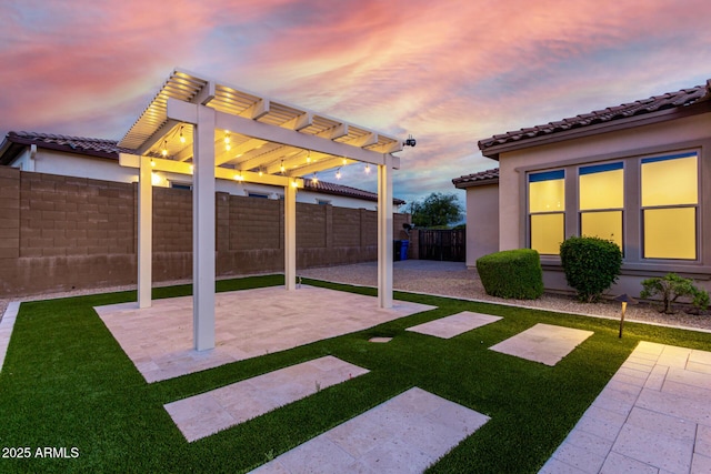 yard at dusk featuring a fenced backyard, a pergola, and a patio