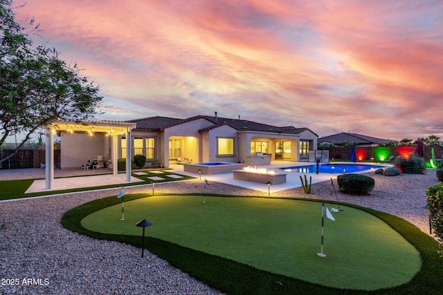 back of house with a tile roof, a pergola, a patio area, a fenced backyard, and a fenced in pool