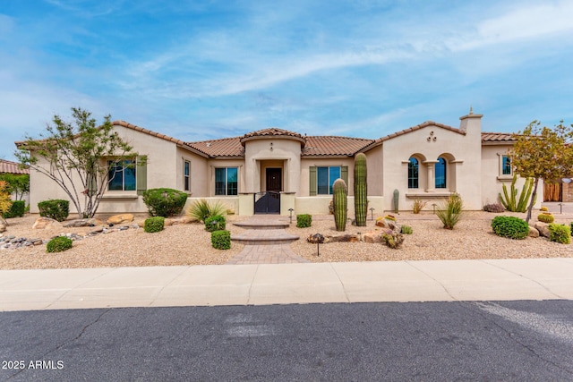 mediterranean / spanish house with a tile roof and stucco siding