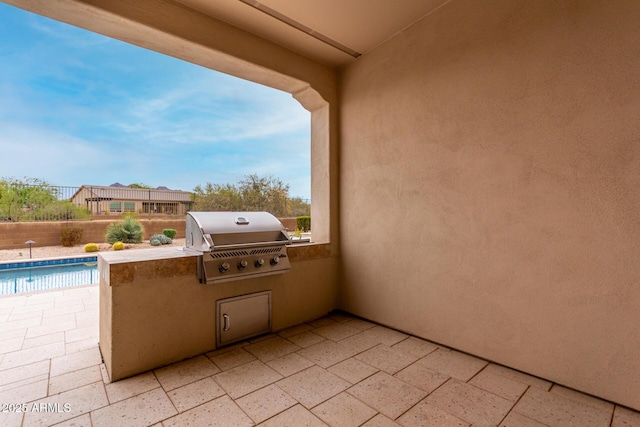 view of patio with grilling area, fence, an outdoor kitchen, and a fenced in pool