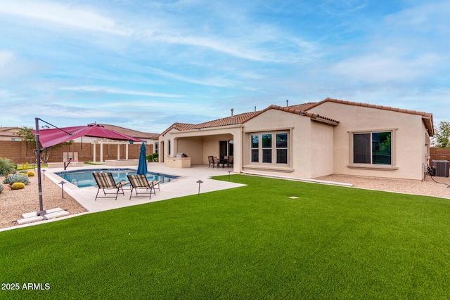 back of house with a fenced in pool, a fenced backyard, a patio area, a lawn, and stucco siding