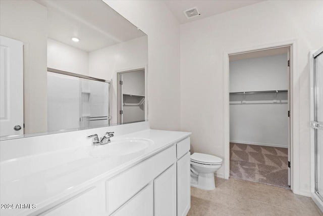 bathroom with vanity, tile patterned flooring, toilet, and walk in shower