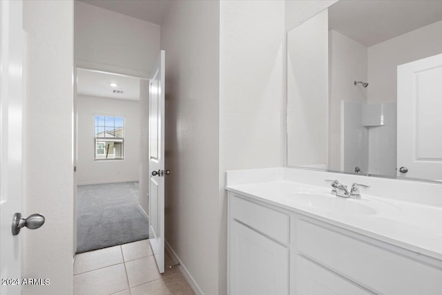 bathroom featuring vanity, a shower, and tile patterned floors