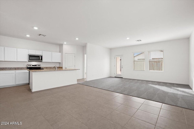 kitchen with light carpet, white cabinets, stainless steel appliances, and sink