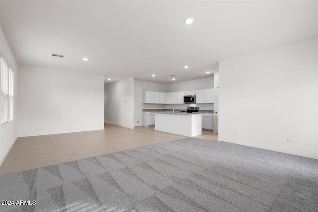 unfurnished living room featuring light carpet