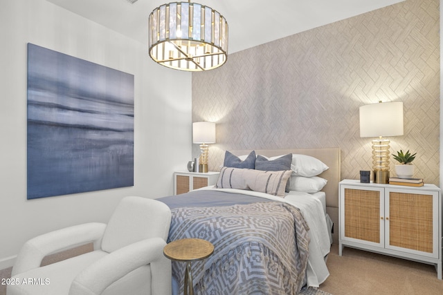 carpeted bedroom with an inviting chandelier