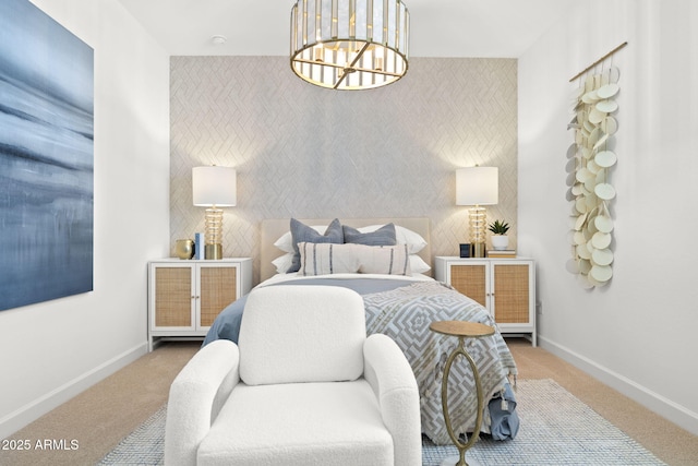 bedroom featuring an accent wall, carpet floors, baseboards, and an inviting chandelier