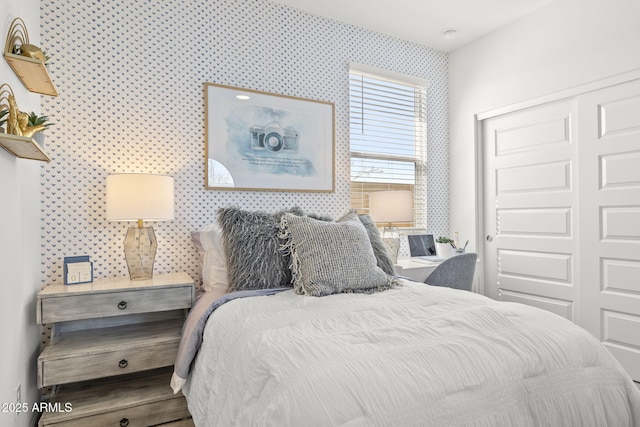 bedroom with a closet and wallpapered walls