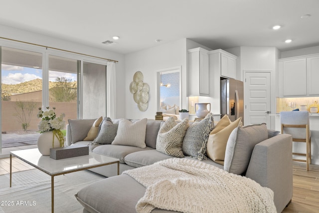 living area featuring light wood-style floors, visible vents, and recessed lighting