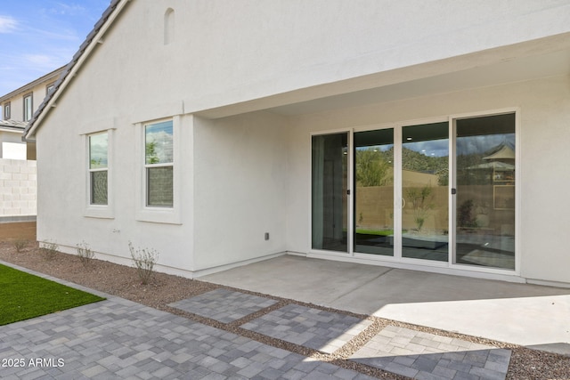 back of house featuring a patio area and stucco siding