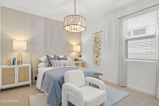 bedroom featuring a notable chandelier, an accent wall, carpet flooring, baseboards, and wallpapered walls