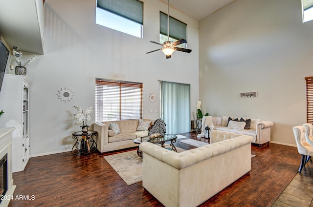 living room with dark wood-type flooring, a high ceiling, and ceiling fan