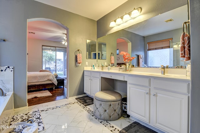 bathroom featuring ceiling fan, a bathtub, and vanity