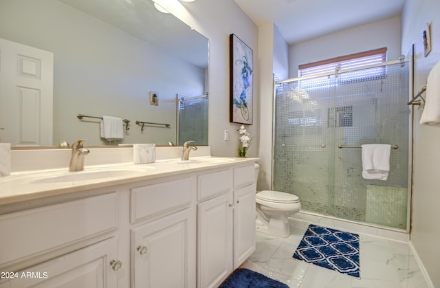 bathroom featuring toilet, a shower with shower door, and vanity