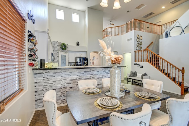 tiled dining area with a towering ceiling and ceiling fan