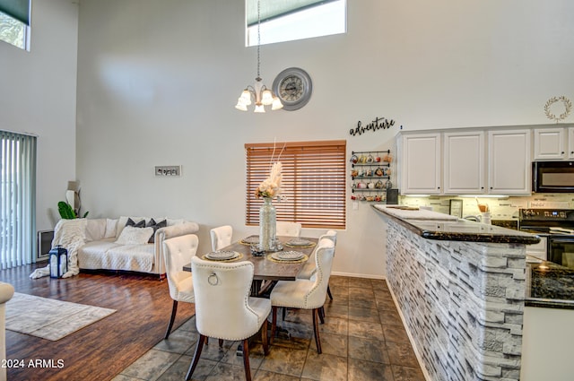 dining room featuring a high ceiling, a wealth of natural light, and a chandelier