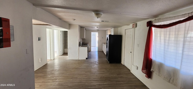 corridor with wood-type flooring and a textured ceiling