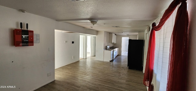 corridor featuring hardwood / wood-style floors and a textured ceiling