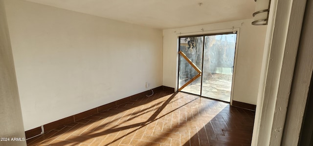 unfurnished room featuring dark parquet flooring