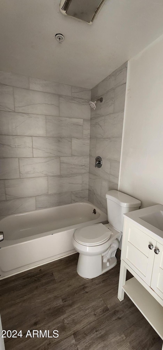 full bathroom with vanity, hardwood / wood-style flooring, toilet, and tiled shower / bath