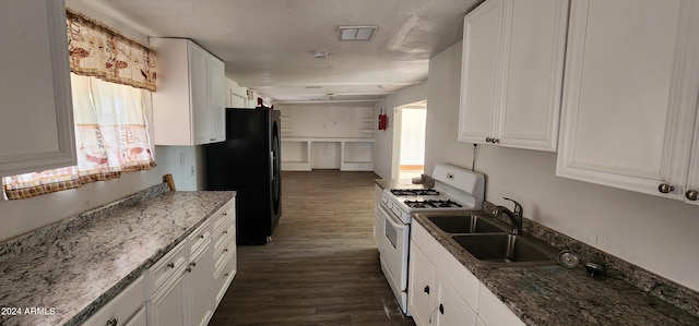 kitchen featuring black refrigerator, white cabinetry, sink, and white range with gas stovetop