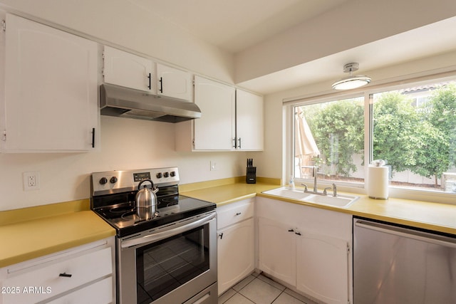 kitchen featuring under cabinet range hood, stainless steel appliances, a sink, white cabinetry, and light countertops