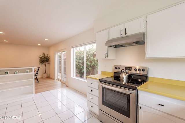 kitchen with electric stove, under cabinet range hood, recessed lighting, light tile patterned flooring, and white cabinets