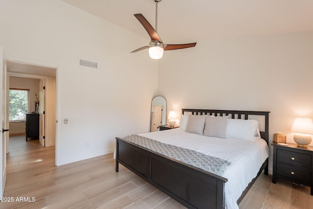 bedroom featuring light wood-type flooring, high vaulted ceiling, baseboards, and ceiling fan
