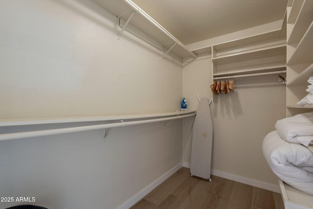 walk in closet with wood finished floors
