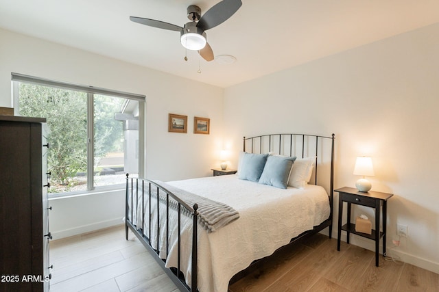 bedroom featuring wood finished floors, baseboards, and ceiling fan