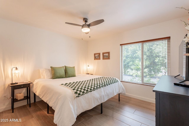 bedroom with baseboards, wood finished floors, and ceiling fan