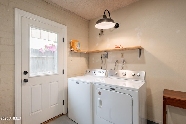 clothes washing area featuring washing machine and dryer and a textured ceiling