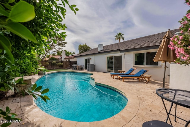 view of swimming pool featuring a patio area, a fenced backyard, and central AC unit