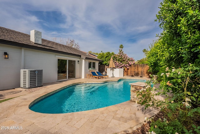 view of pool featuring a patio area, a fenced backyard, and central AC