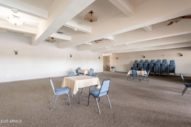 carpeted dining room with beam ceiling and baseboards