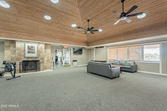 carpeted living area with a tiled fireplace, baseboards, a ceiling fan, and high vaulted ceiling