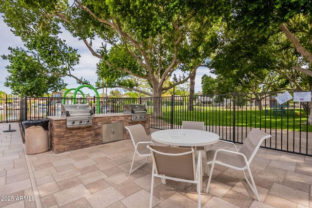 view of patio with grilling area, fence, and an outdoor kitchen