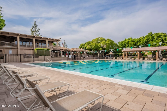 community pool with fence and a patio