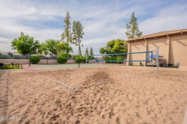 view of property's community featuring volleyball court, community basketball court, and fence